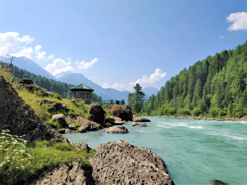 a small building on a rocky cliff over a body of water