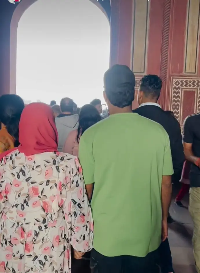 A group of tourists admiring the white marble beauty of the Taj Mahal.