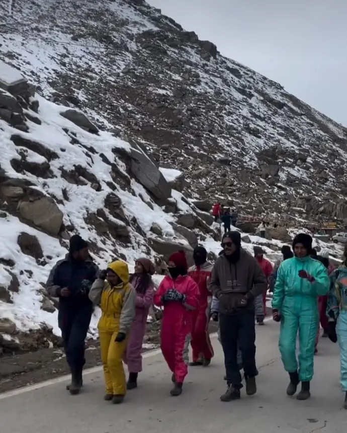 A group of friends trekking through a snowy landscape on their Kullu Manali adventure